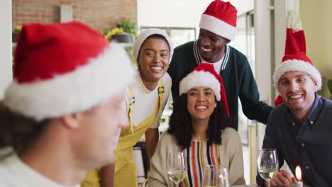 Happy-group-of-diverse-friends-celebrating-meal,-taking-selfie-at-christmas-time