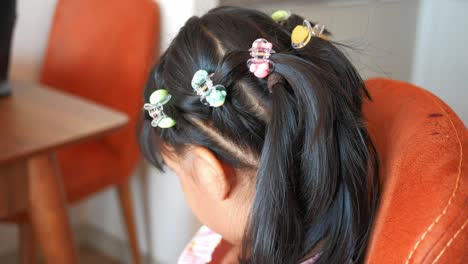 cute little girl with colorful hair clips in ponytail hairstyle