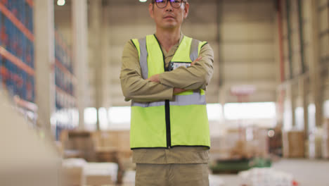 retrato de un trabajador masculino asiático con traje de seguridad en un almacén