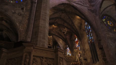 female tourist appreciating cathedral architecture pan up to ceiling with stained glass windows