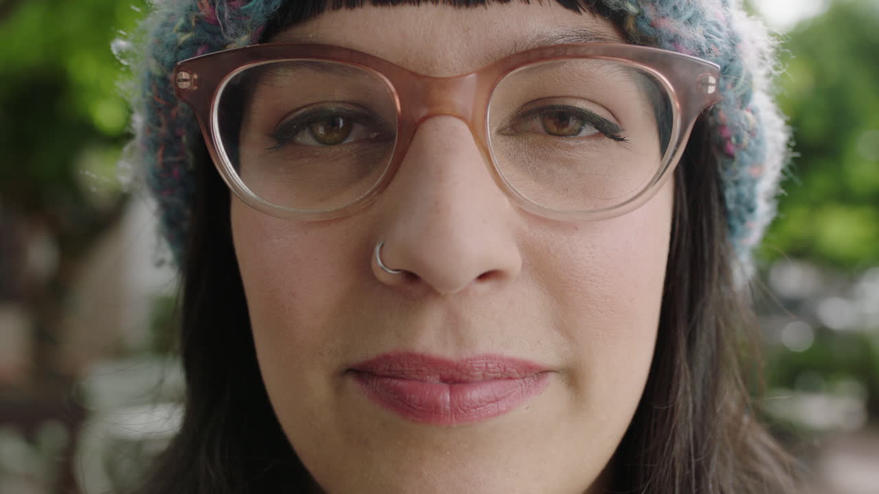 retrato de una mujer hipster con gafas funky que parece seria y pensativa ante la cámara