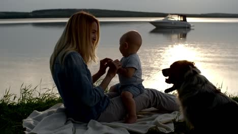 mother and toddler relaxing by lake in evening