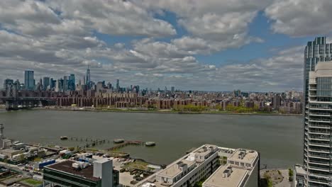 Drone-flight-over-Greenwich-District-and-East-River-and-skyline-in-background-during-cloudy-day---Luxury-Apartments-at-shore-in-New-York-City