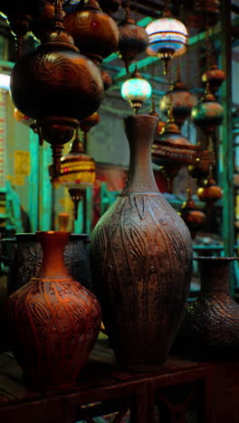 close up of clay vases and hanging lamps in a shop