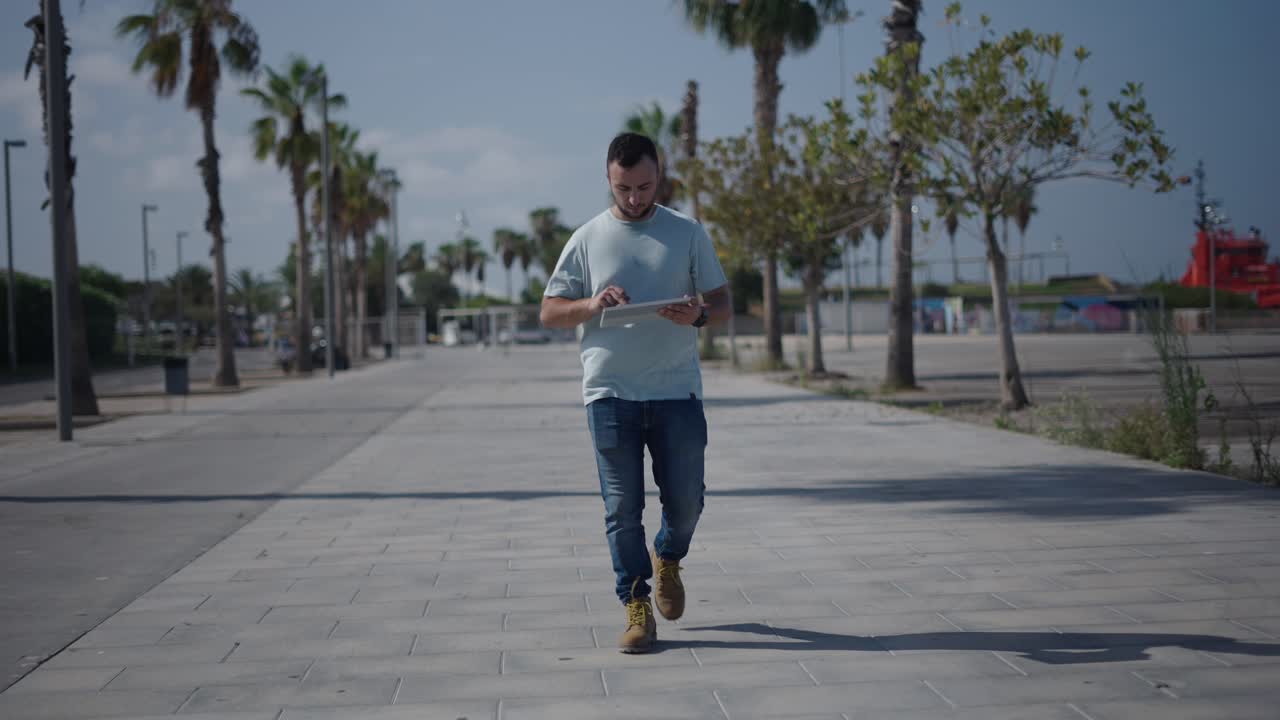 Man walking outdoors with tablet