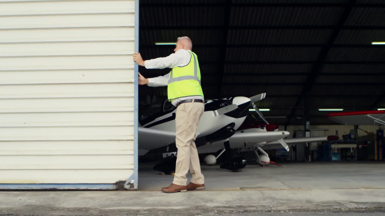 Male engineer opening shutter of hangar 4k