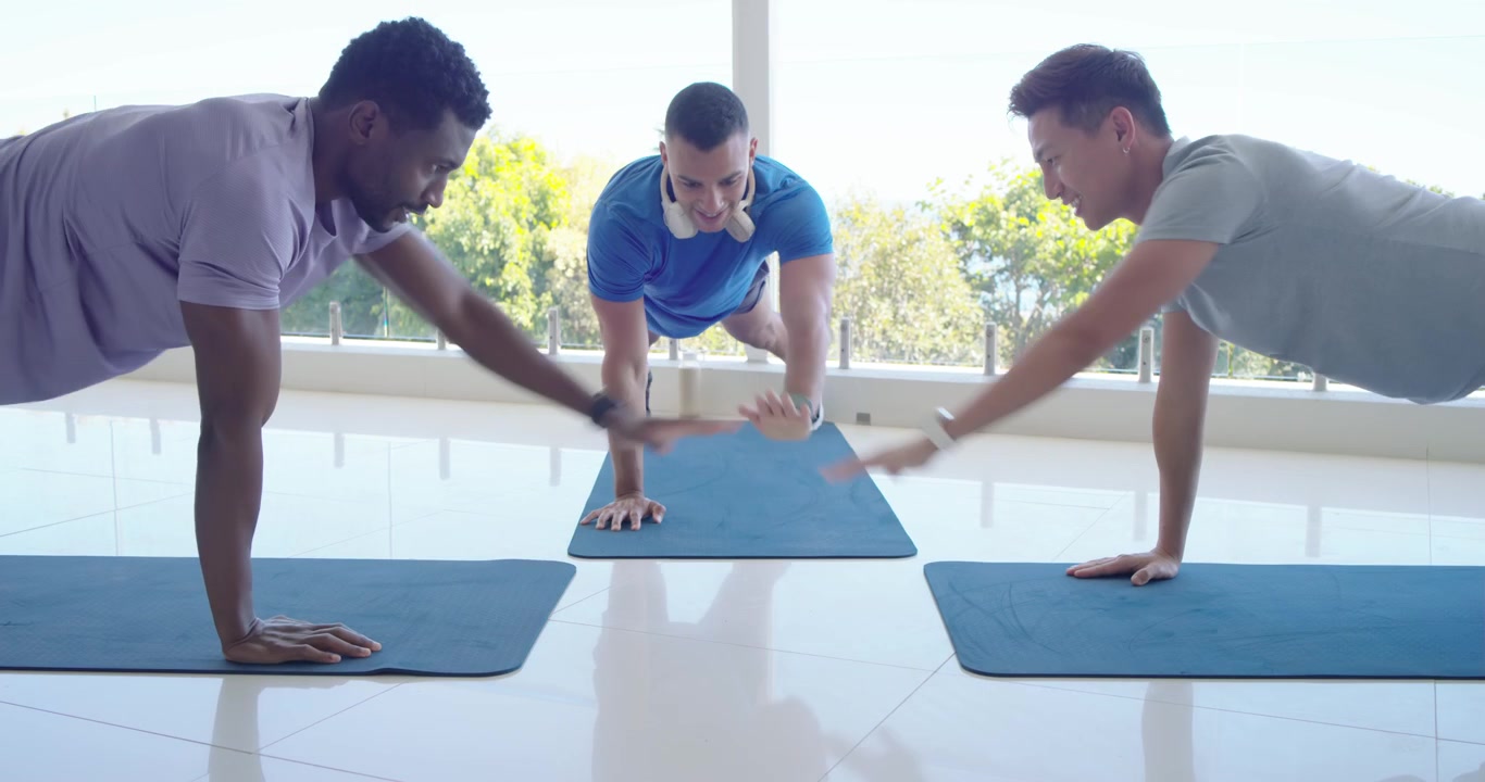 Diverse men starting low doing pushups center doing plank left dropping resuming workout by window