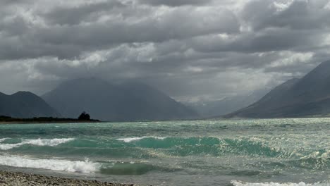 heavy storm clouds touching peaks of alpine mountain range at lake ohau, new zealand