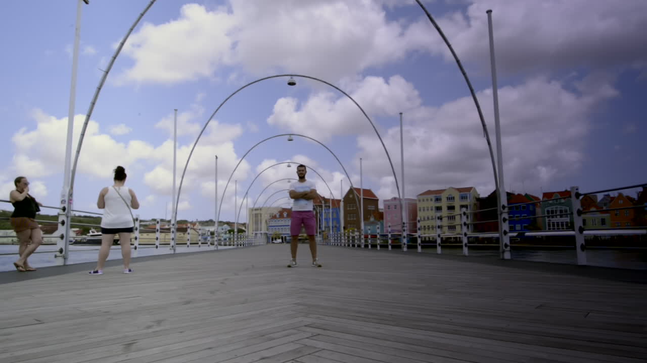 Tourist over opening Queen Emma Bridge. Willemstad, Curaçao. Tourism in Sint Anna Bay. Travel time lapse