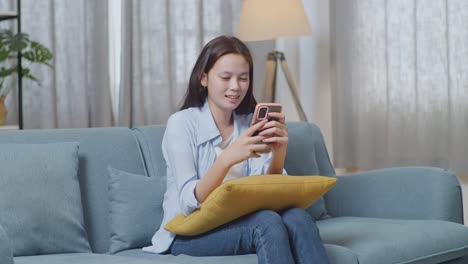 woman using a smartphone on a couch