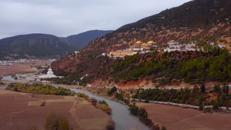 templo religioso dorado parada de peregrinación con vistas al hermoso río en otoño, al pueblo del valle de yading