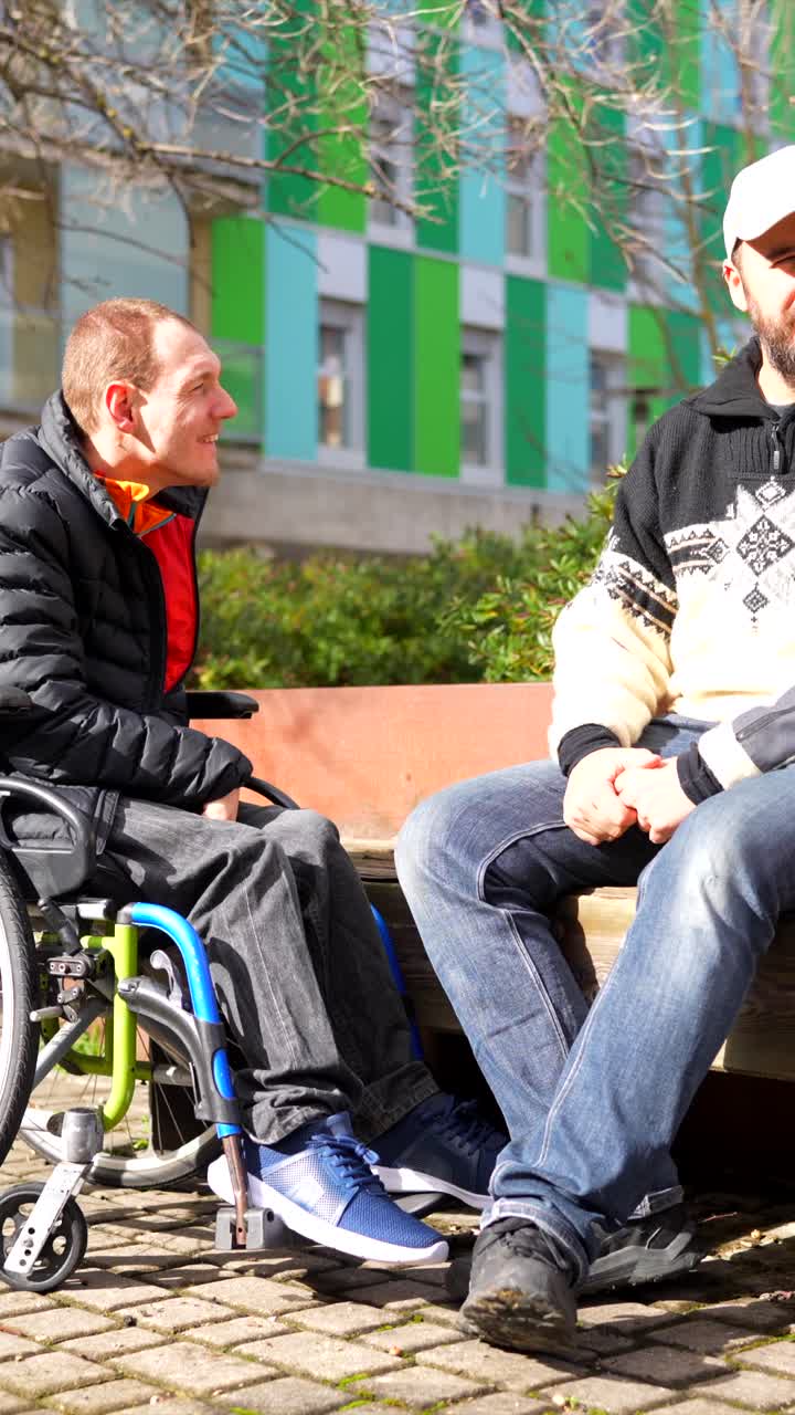 Two Men Conversing Outdoors, One in a Wheelchair