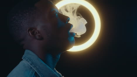 man smoking against ring light