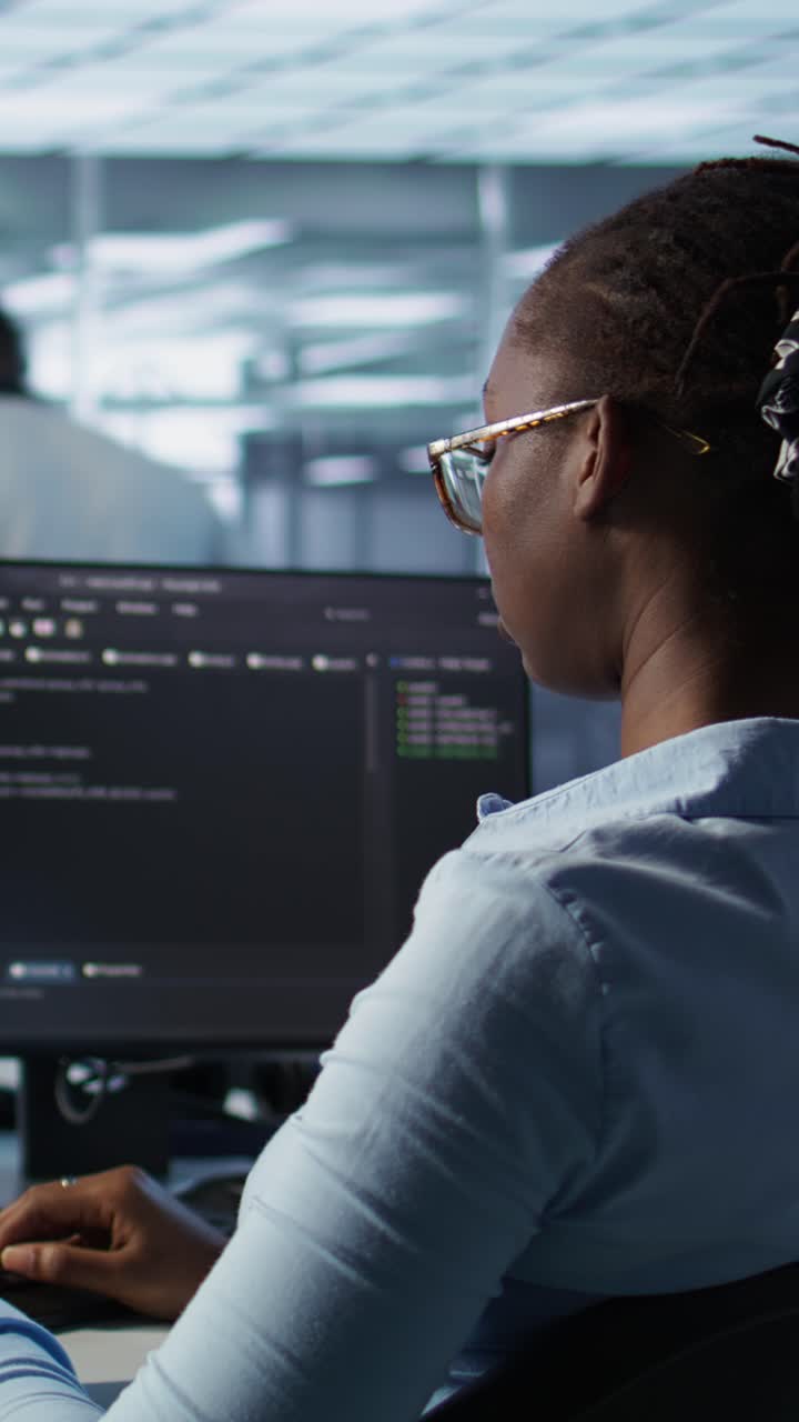 African American Woman Programmer Typing Code on Computer in Office