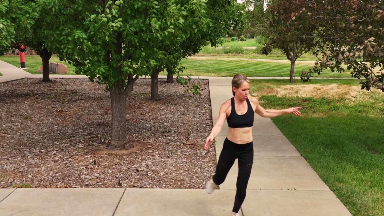 A muscular woman inspires running training by demonstrating proper cross step form