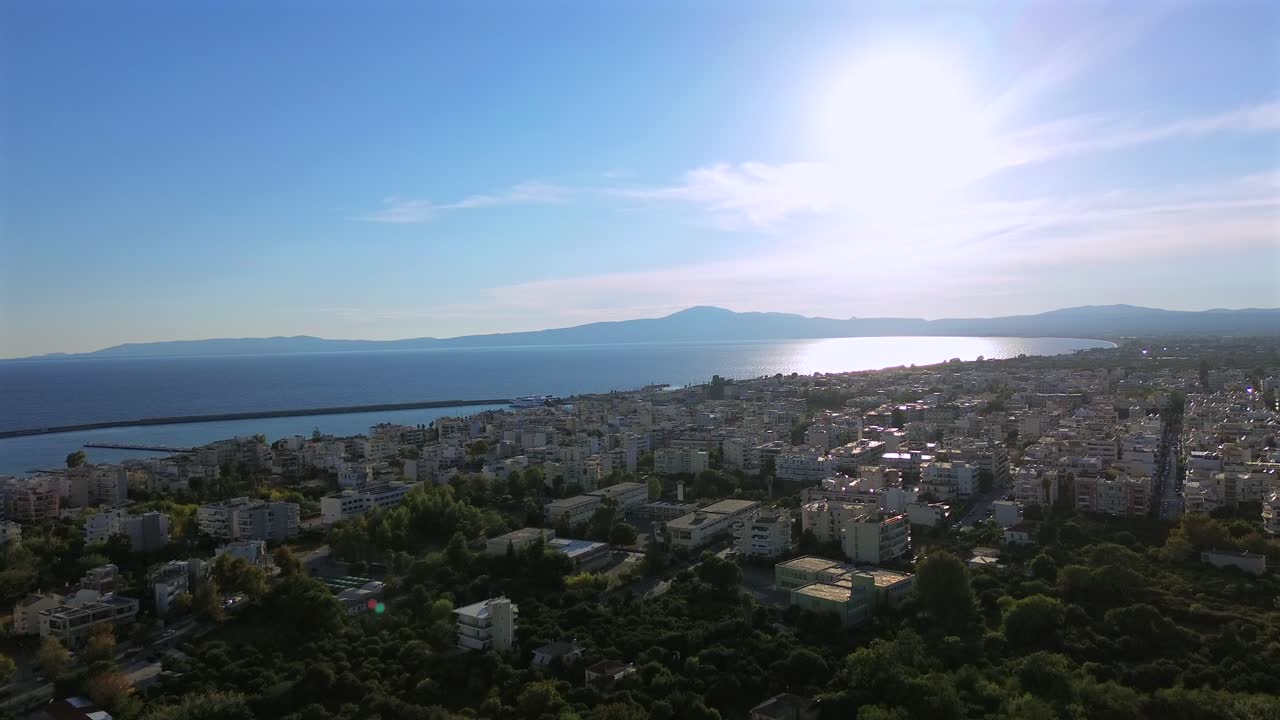 Aerial. push in footage, flying over the city of Kalamata, revealing the Messinian gulf, on a bright day of autumn with clear blue sky and bright sun light 4K