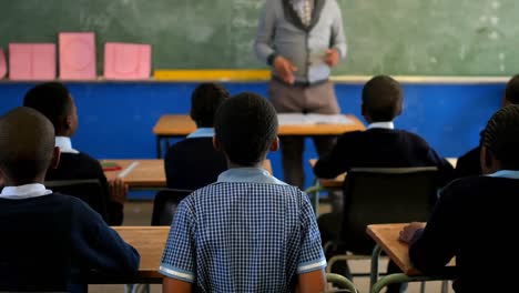 male teacher teaching students in the class 4k