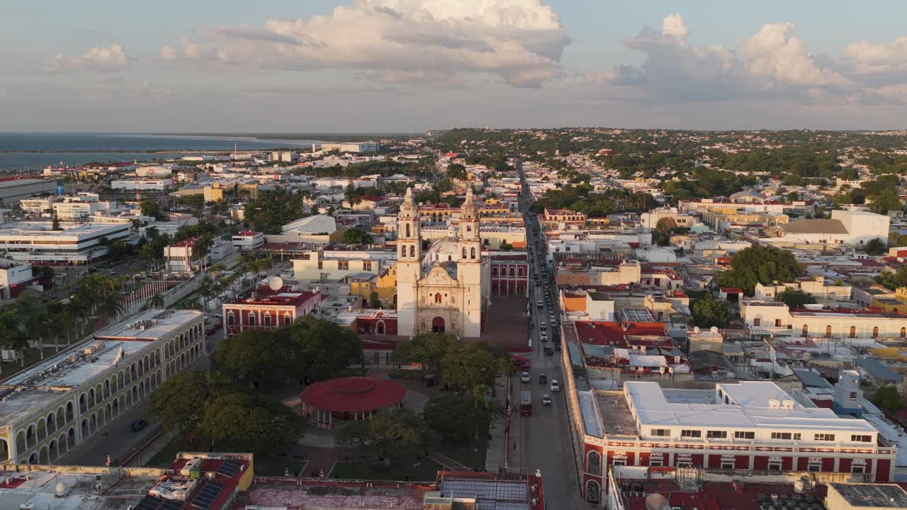 Static drone view of Campeche’s Cathedral and central plaza with surrounding colonial cityscape in warm evening light