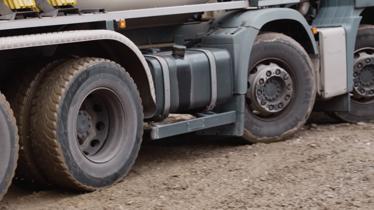 Close-up of heavy truck wheels on muddy construction site. Great for industrial projects or transportation ads