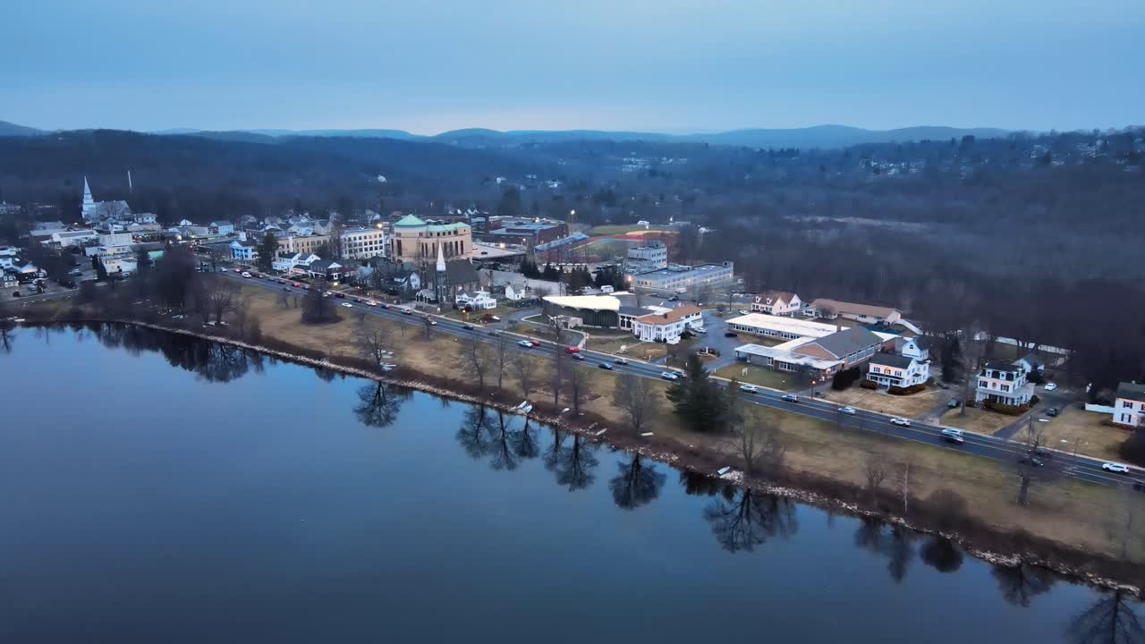 imágenes aéreas acercándose a una pequeña ciudad lacustre en estados unidos justo después del atardecer