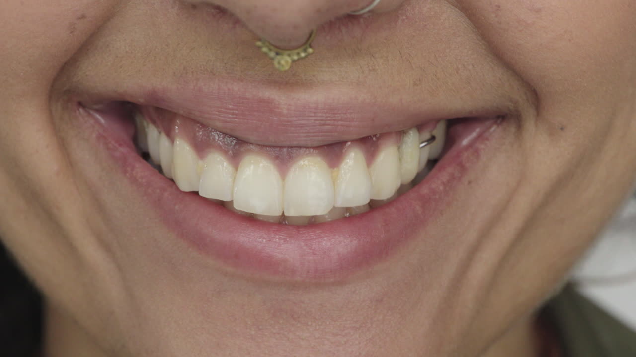 cerca boca de mujer joven sonriendo satisfacción feliz encías sanas dientes blancos concepto de salud dental usar anillo en la nariz