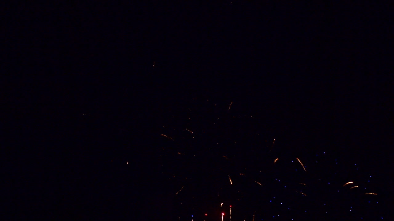 los cohetes fluyen hacia el cielo nocturno y explotan con color contra un fondo negro