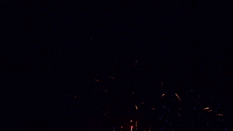 los cohetes fluyen hacia el cielo nocturno y explotan con color contra un fondo negro