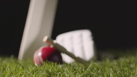 cricket still life with close up of bat ball bails and gloves lying in grass 2