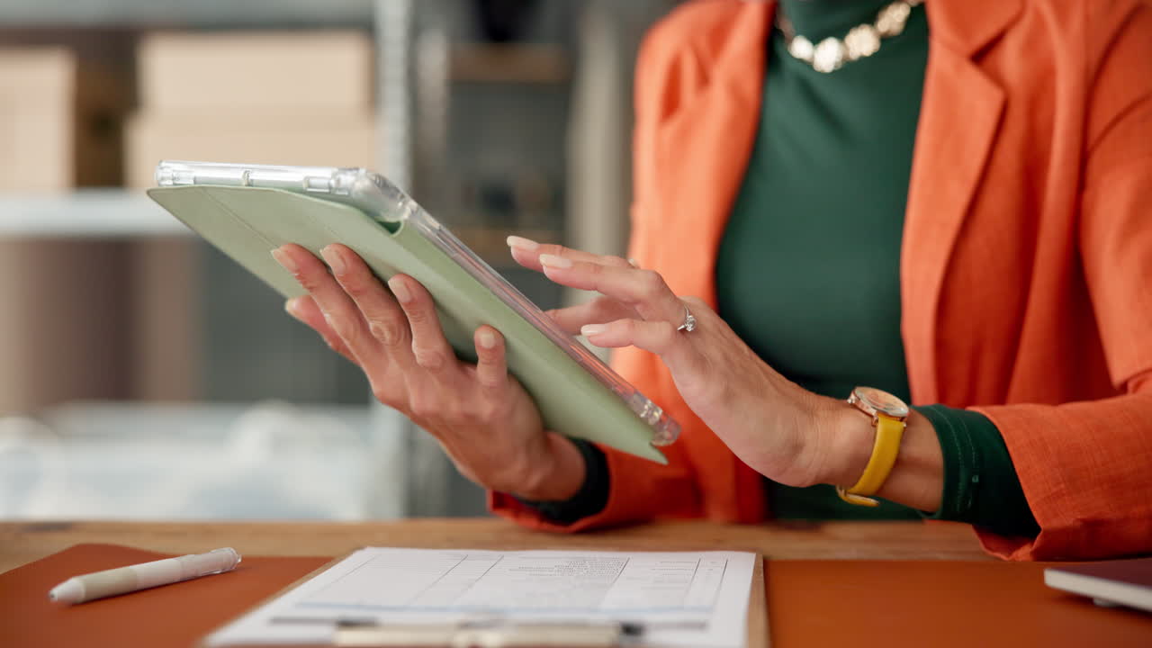 Close Up of Woman's Hands Using a Digital Tablet at a Desk