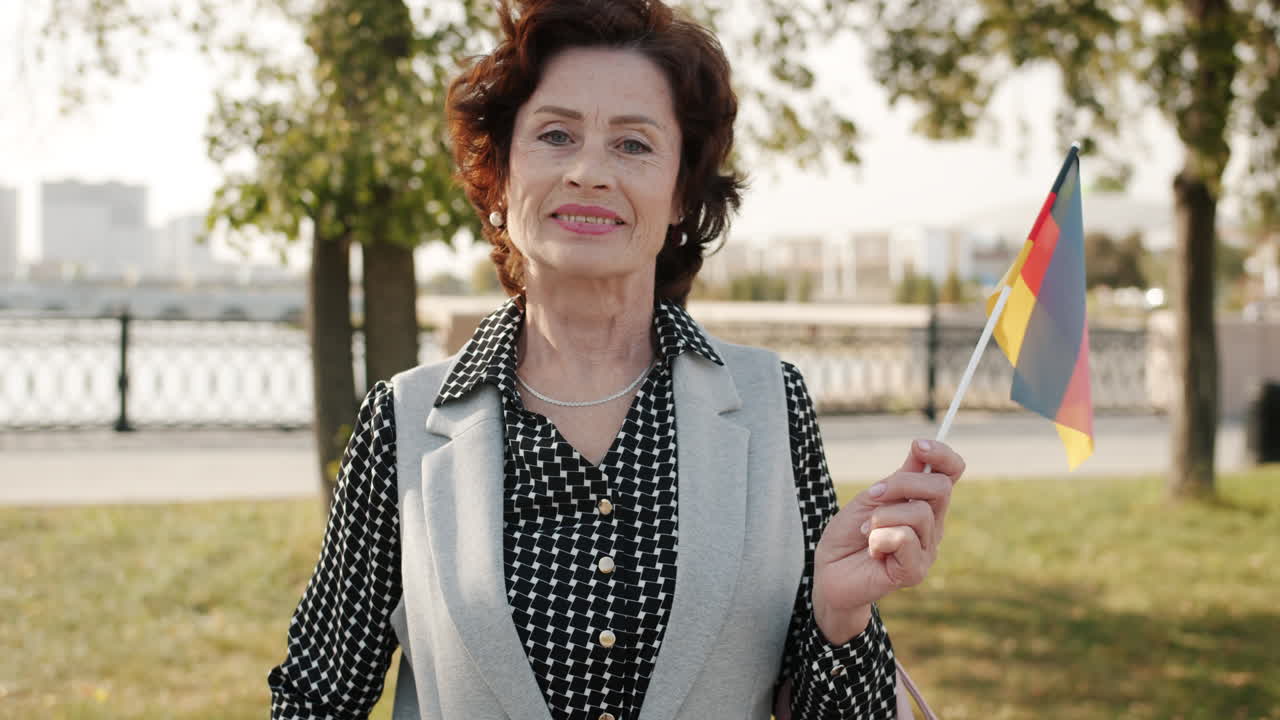 Senior Woman Holding German Flag in a Park
