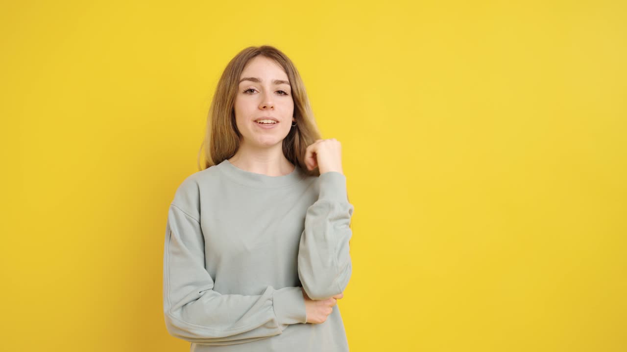 Young woman thinking and having an idea on yellow background