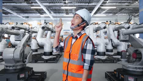 ingeniero inspeccionando robots industriales en una fábrica
