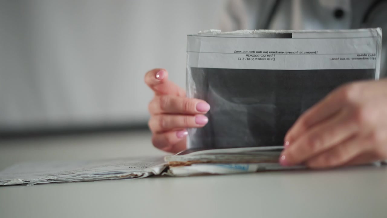 Læge gennemgår billeder. En medicinsk fagperson analyserer omhyggeligt billeddiagnostik og patientjournaler. En sundhedsekspert vurderer roligt røntgenbilleder i forbindelse med patientens sygehistorie.