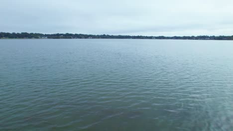 Flyover-of-fishing-dock-on-Starke-Lake-and-cloudy-sky-in-Ocoee,-Central-Florida