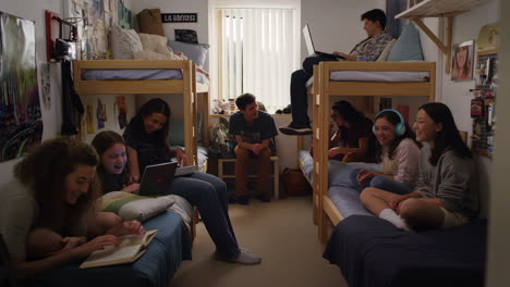 students socializing and studying in a shared college dorm room