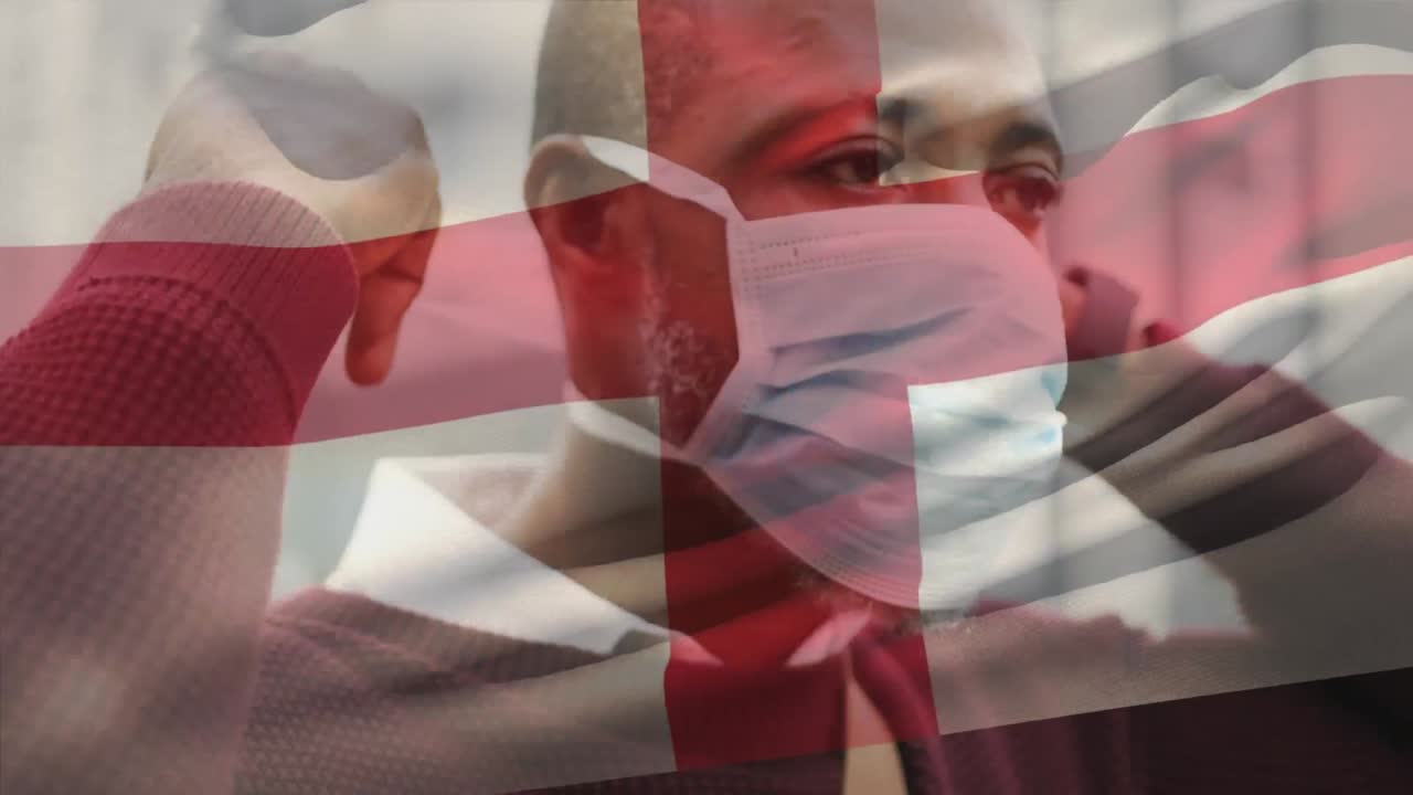 코로나19 전염병 기간 동안 마스크를 쓴 남자가 영국 국기를 흔들고 있는 애니메이션