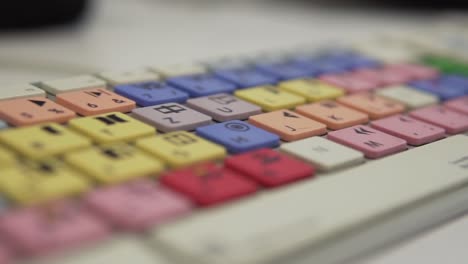 cámara lenta: captura de seguimiento de un teclado de editores con teclas coloridas, primer plano