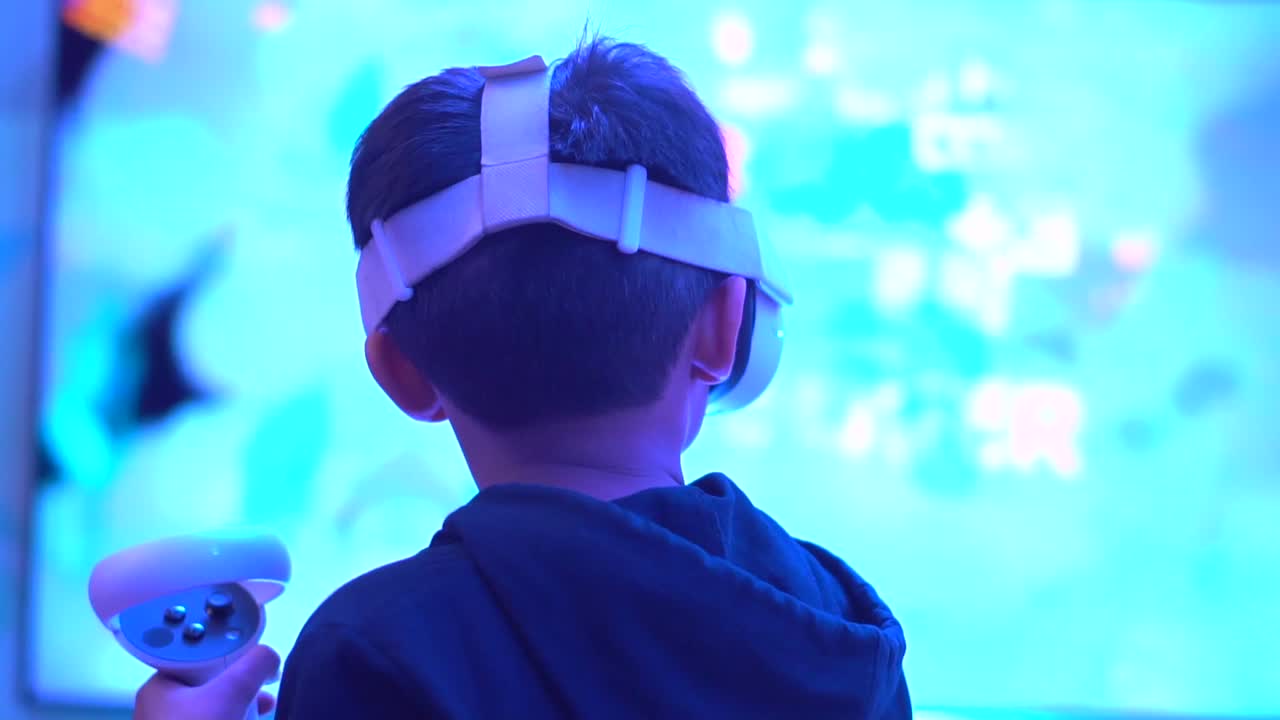 niño jugando juegos en el controlador vr desde la vista lateral trasera