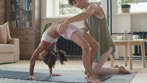 young girl practicing yoga with instructor