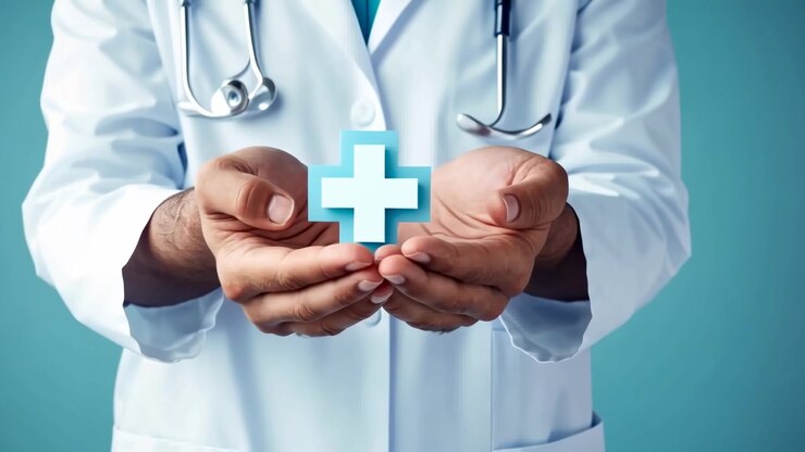 Médico sosteniendo el símbolo de la cruz médica en sus manos ahuecadas