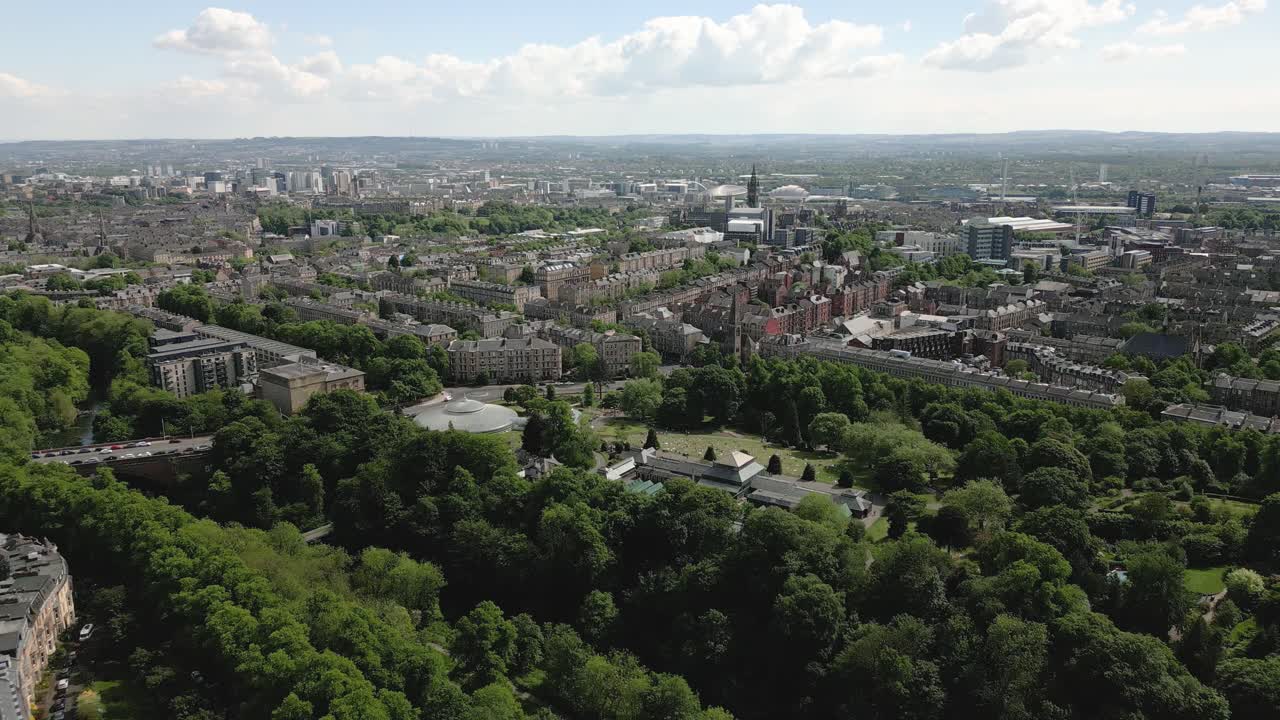 Aerial backwards reveal of Glasgow Botanic Gardens with Kibble Palace and Glasgow West End in frame, Scotland, UK