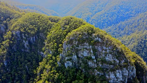 drone aéreo moviéndose hacia atrás disparado sobre la cordillera en el cañón de laven, tasmania, australia en un día soleado