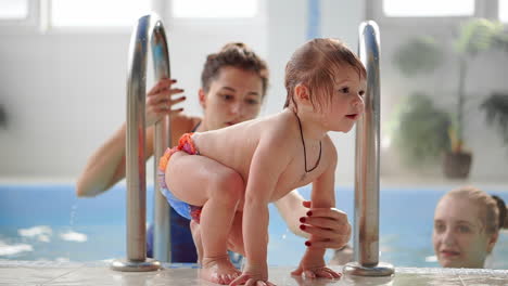 the baby's coming upstairs from the swimming pool helps the mother in slow motion