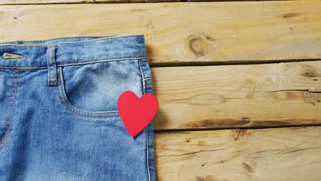 Close-up-of-jeans-with-red-heart-on-wooden-background-with-copy-space
