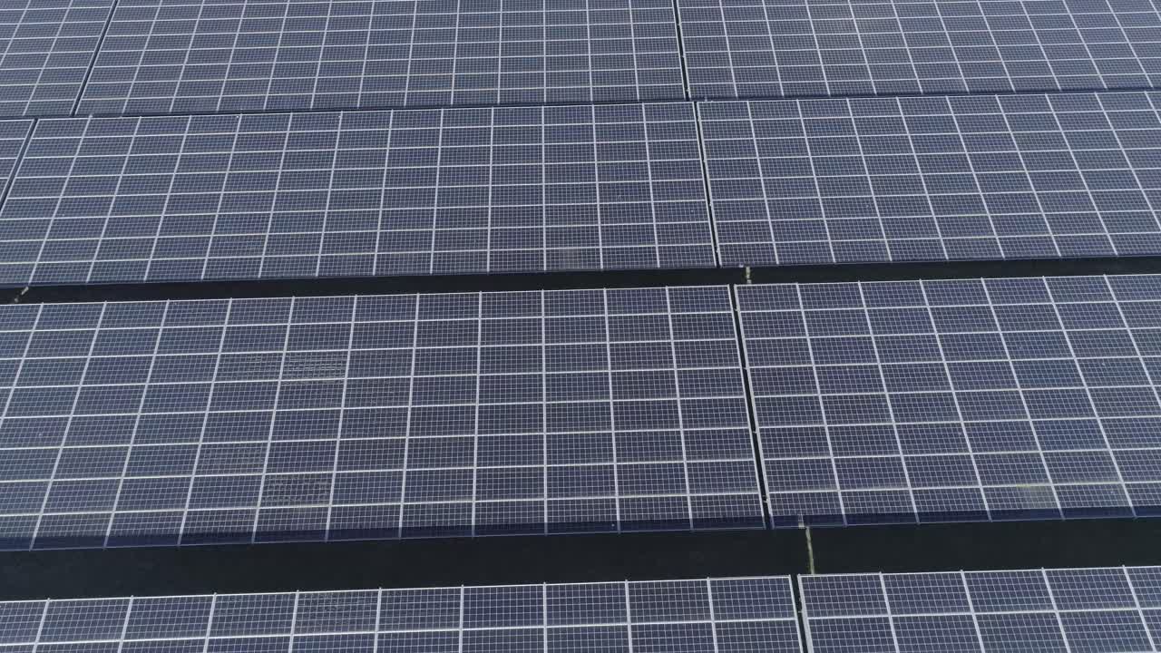 disparo de drones de cerca a más lejos de un campo con paneles solares