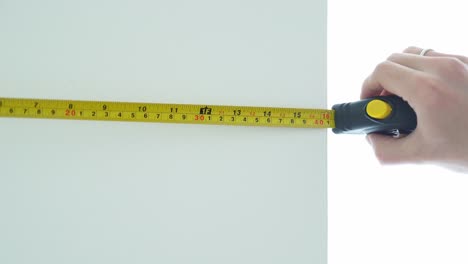 male hand using a tape measure to measure things