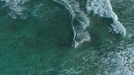 un surfista atrapando una ola - vista aérea