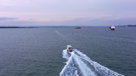 Passenger-boat-leaving-Port-of-Balikpapan-city-in-the-evening---Aerial-shot---Indonesia