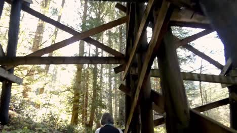 older lady walking under a trestle with sun flares