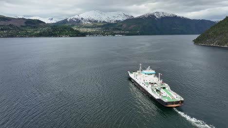 ferry to stranda in more and romsdal norway - ferry named volda is underway with stranda town seen in background below snow capped mountain